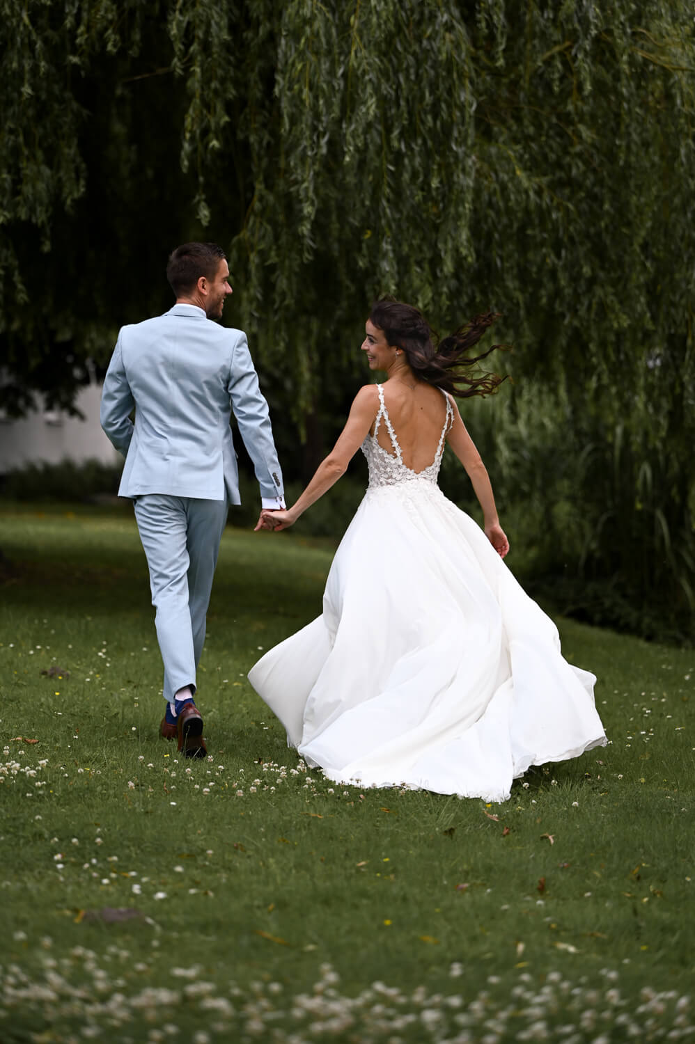 Ein Brautpaar läuft über eine Wiese bei einem Hochzeitsshooting in Rostock - Hochzeitsfotografie