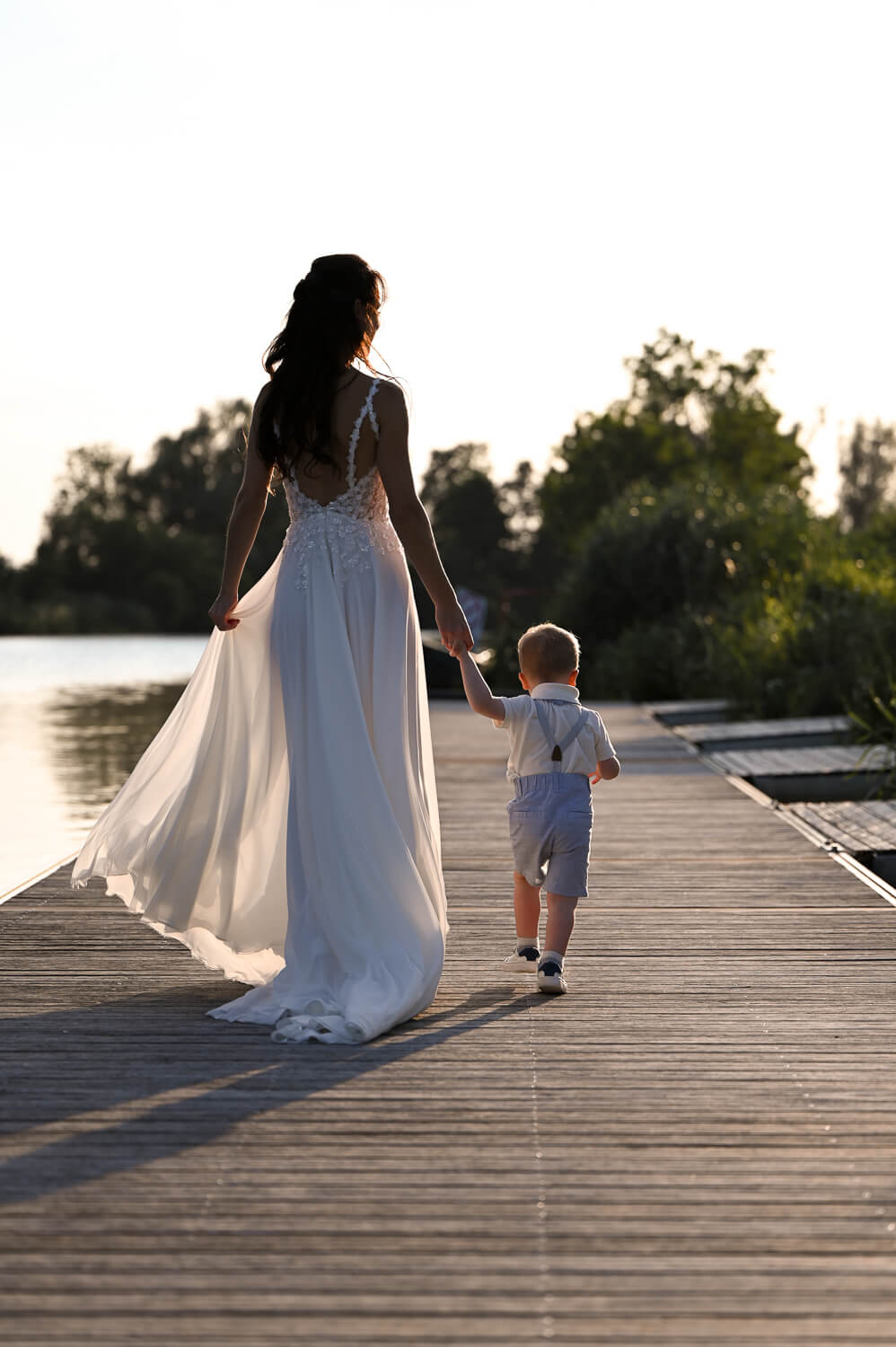Die Braut mit ihrem Sohn im Sonnenuntergang bei einem Hochzeitsshooting in Rostock