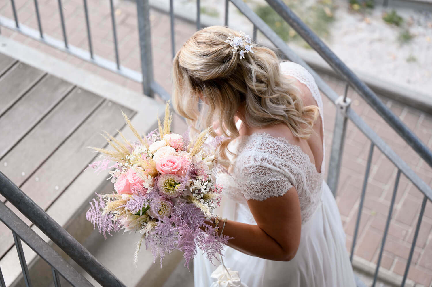 Die Braut kommt die Treppen hoch bei einem Hochzeitsshooting in Rostock