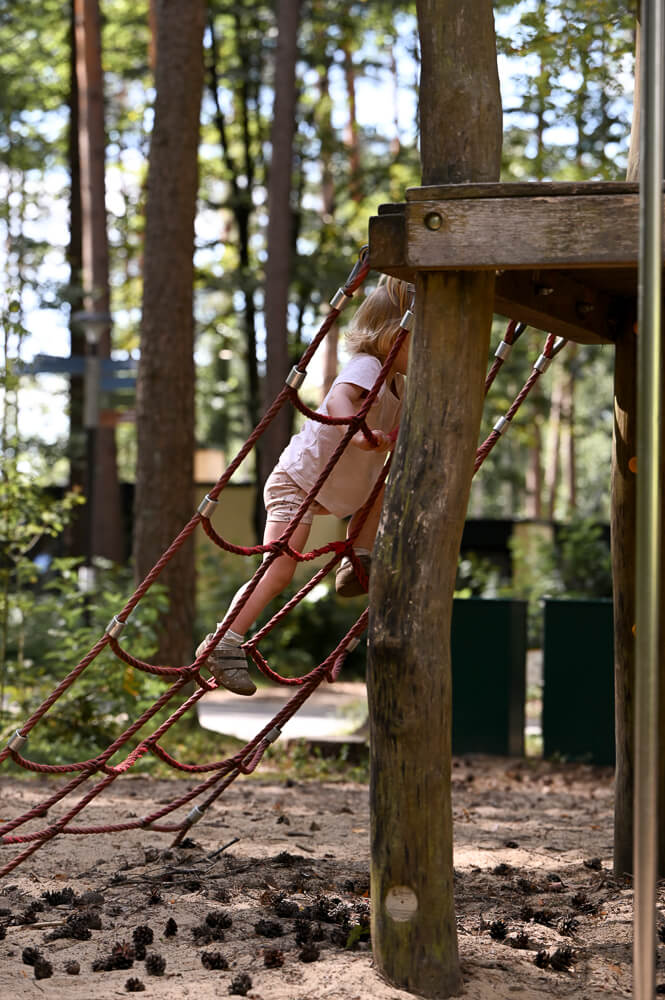 Ein kleines Mädchen klettert auf einem Spielplatz bei einem Familienshooting in Rostock