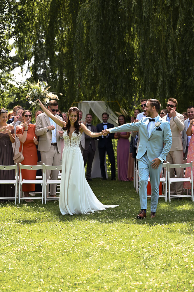 Frisch verheiratet - Ein Brautpaar vor den jubelnden Gästen bei einem Hochzeitsshooting in Rostock
