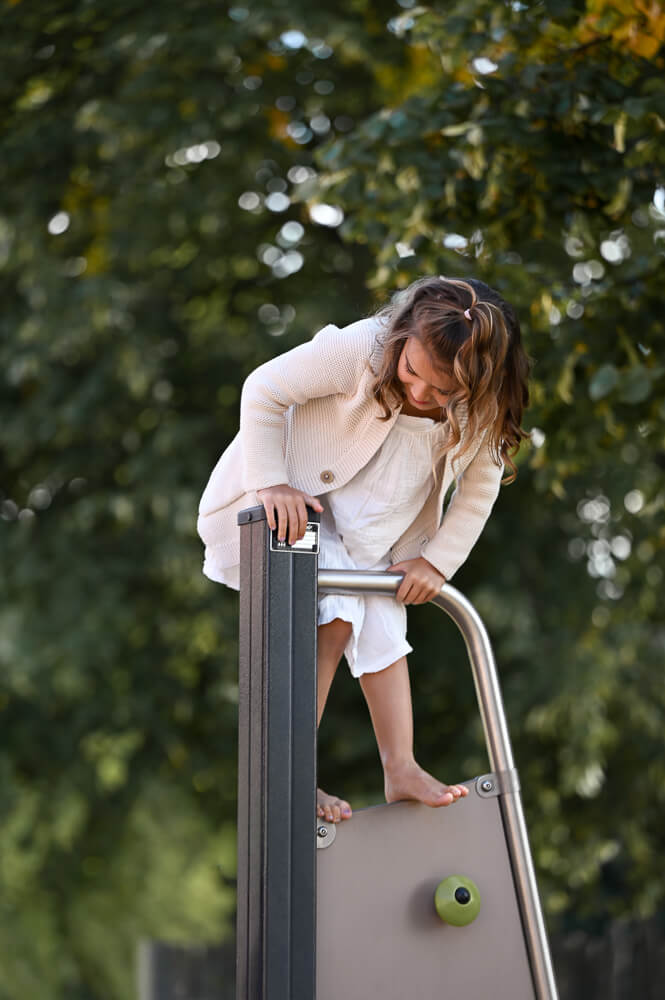 Ein Mädchen klettert bei einem Familienshooting in Rostock auf einem Klettergerüst