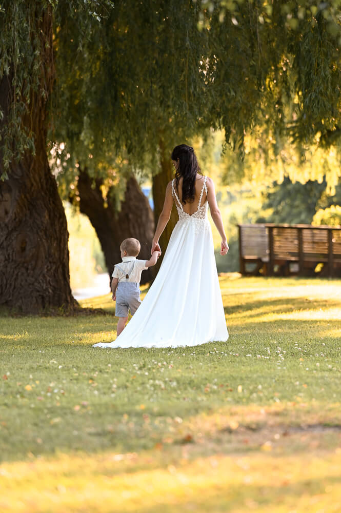 Die Braut läuft mit ihrem Sohn in Richtung Warnow bei einem Hochzeitsshooting in Rostock