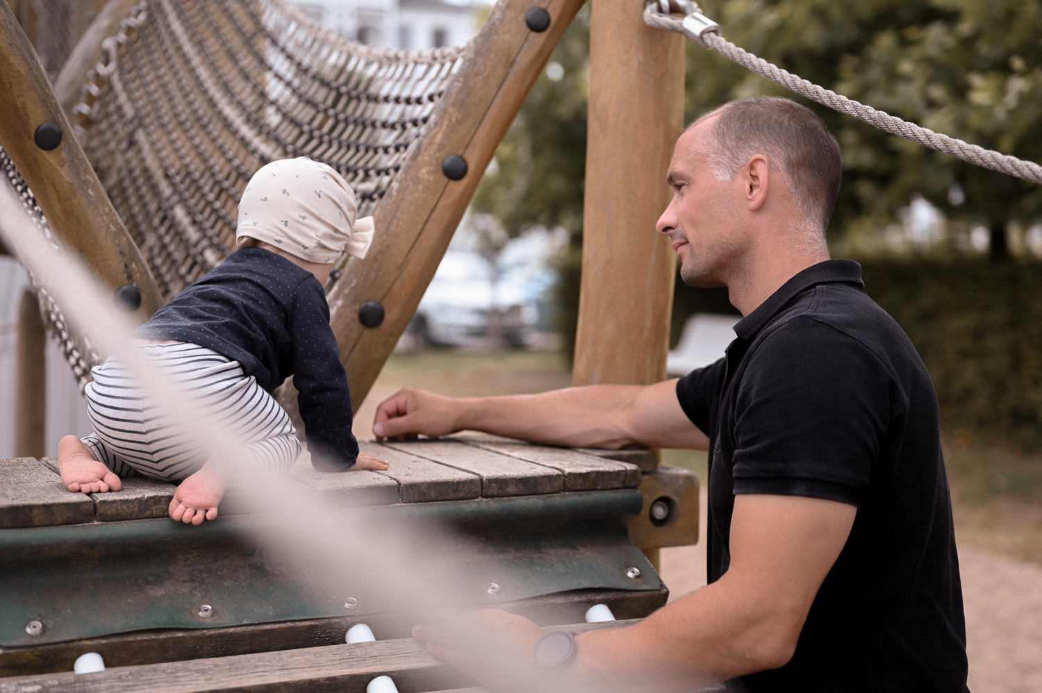Ein Papa auf dem Spielplatz mit seinem Kleinkind bei einem Familienshooting in Rostock